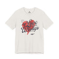 Cream Love Covers All Wrongs tee with a red heart and dark script lettering across the front.